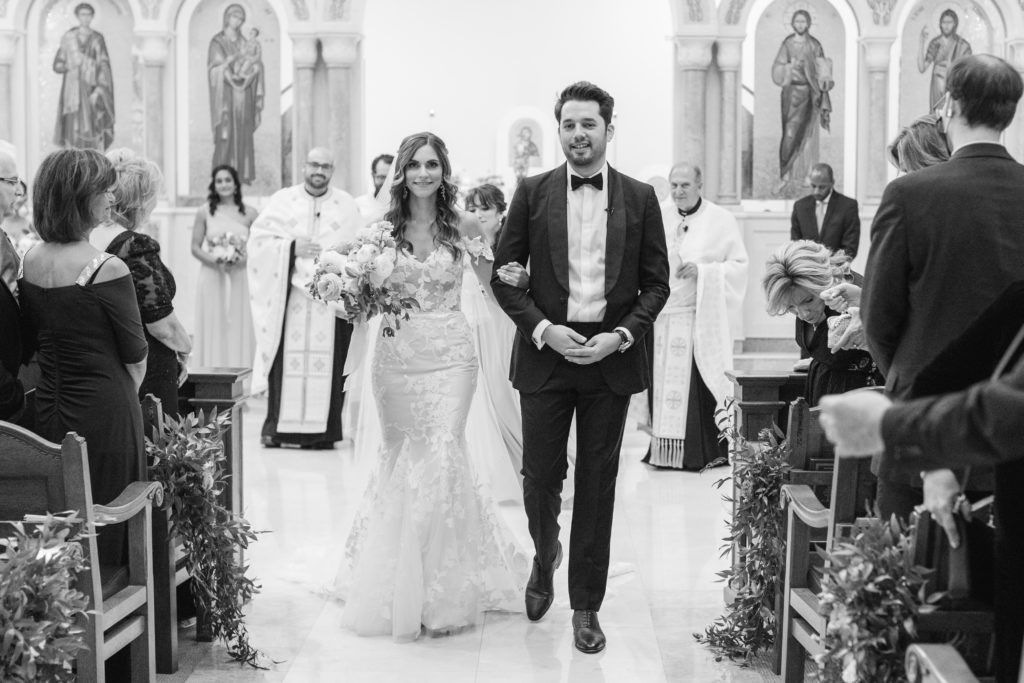 bride and groom walking down the aisle in greek orthodox church