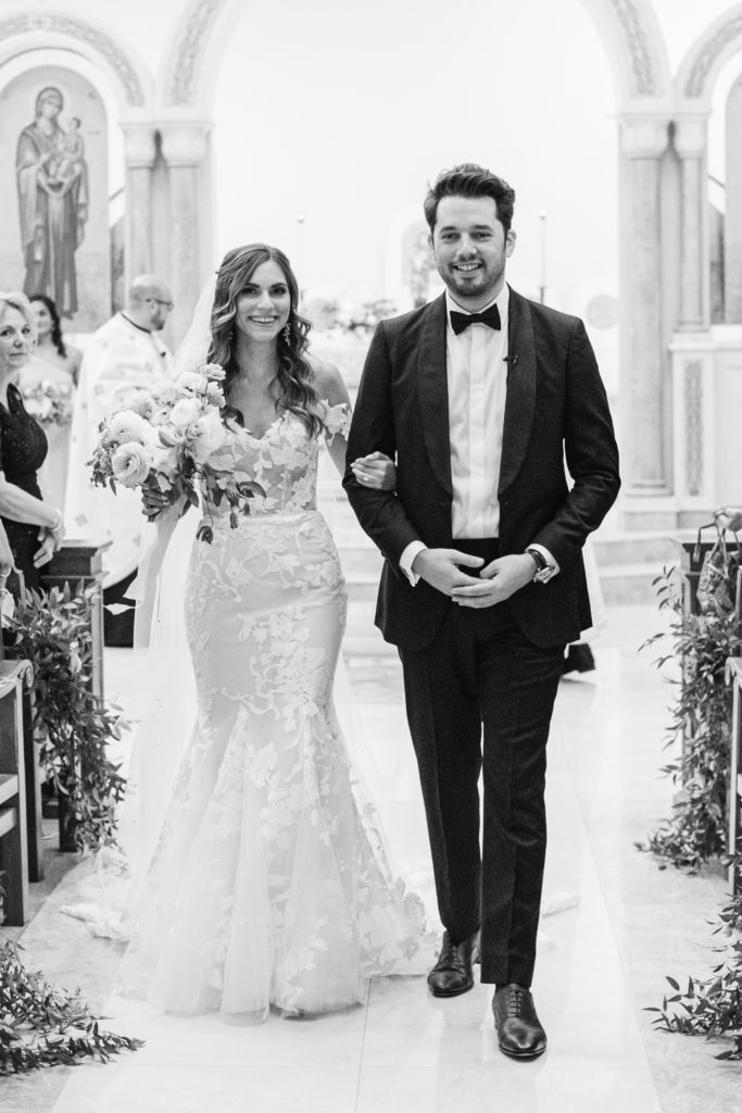 bride and groom walking down the aisle in greek orthodox church