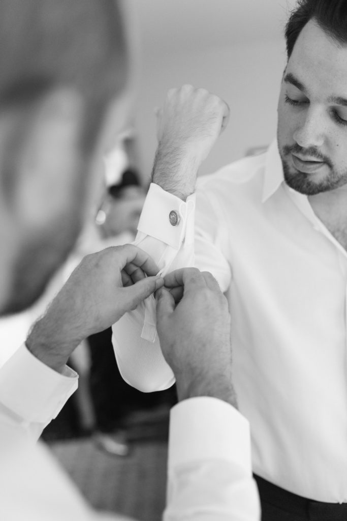 groom putting on cufflinks